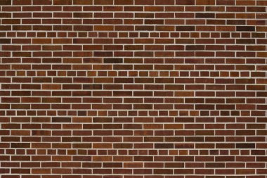 Geleneksel kahverengi desenli tuğla duvar arkaplanının ön görünümü beyaz harç ve ortak bir tahvil kalıbı.