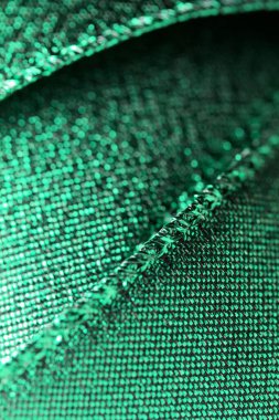 Parlak metalik yeşil kumaş kurdele soyut arka plan, fotokopi alanı ve bokeh ile ışıltılı doku