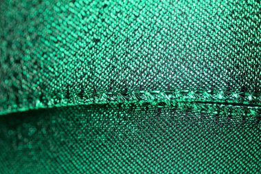 Parlak metalik yeşil kumaş kurdele soyut arka plan, fotokopi alanı ve bokeh ile ışıltılı doku