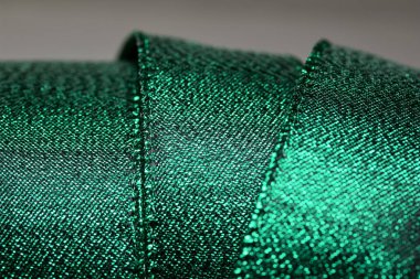 Parlak metalik yeşil kumaş kurdele soyut arka plan, fotokopi alanı ve bokeh ile ışıltılı doku