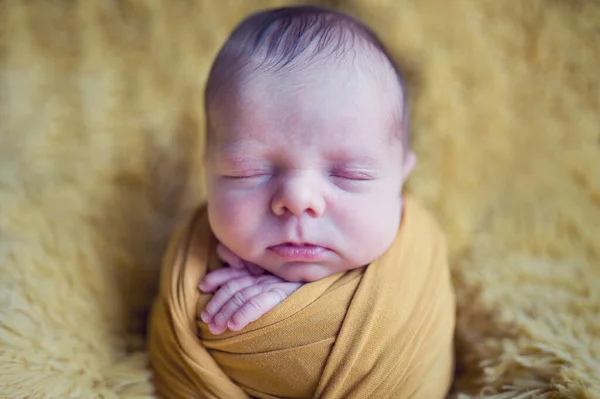 新生儿睡觉时男婴或女婴的照片 像裹着黄色包扎在毛毯背景上的新生儿土豆 — 图库照片
