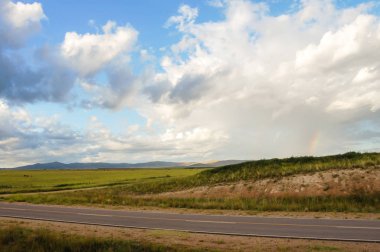 Dağların manzarası, patika ve bulutlu düzlükler.