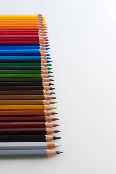 Färgpennor på grå bakgrund, i linje med nedbrytning — Stockfoto