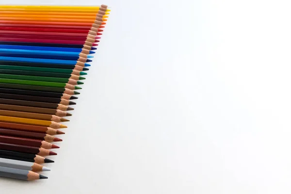 Цветные карандаши на белом фоне, выровненные по степени деградации — стоковое фото