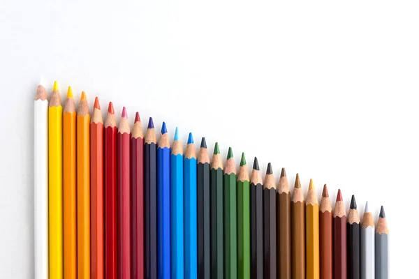 Цветные карандаши на белом фоне, выровненные по степени деградации — стоковое фото