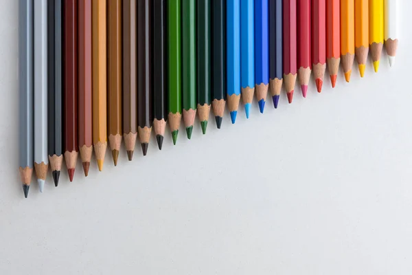 Färgpennor på grå bakgrund, i linje med nedbrytning — Stockfoto