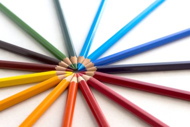 Beyaz arka planda renkli kalemli figürler. Renklere göre sıralanmış kalemler.