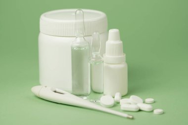 Beyaz ilaç ve tıbbi hazırlıklar şişeler, cam ampuller, yakın plan yeşil arka plan. Fotokopi makineleriyle tıbbi hazırlıkların yakın plan fotoğrafı.