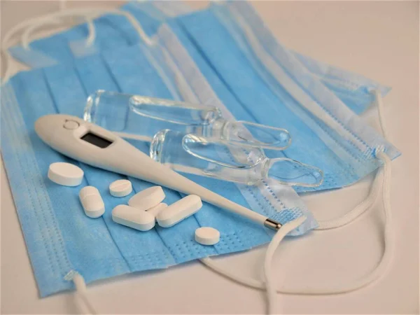 Covid Epidemie Blaue Medizinische Einmalmasken Thermometer Pillen Und Medizinische Ampullen — Stockfoto