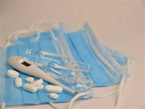 Covid Epidemie Blaue Medizinische Einmalmasken Thermometer Pillen Und Medizinische Ampullen — Stockfoto