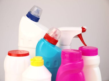 Bir grup deterjan, ev içi ve dışarısı için dezenfektanlar beyaz arka planda parlak plastik şişelerde kullanılıyor. Yakın plan. Evi temizleme kavramı..