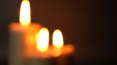 Siyah arka planda yanan üç mumdan oluşan bir grup. Konfor kavramı, romantizm, mistik, okültizm, din, bir hafıza sembolü. Mum ışığı titremesi, seçici odaklanma, dağılma..