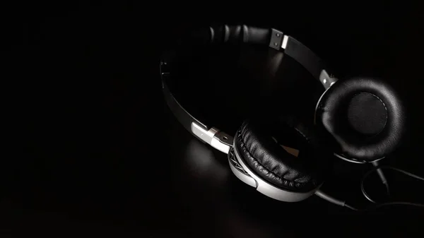 Black headphones isolated on a black background,close up.