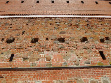 Background wall of the old castle of red stone and brick