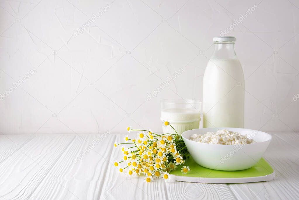 Kefir drink with and fermented dairy product curd with flowers on the white background with copy space. Horizontal orientation. Kefir Lose weight diet concept.