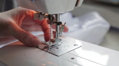Terzi dikiş makinesini ipliğe geçirir.