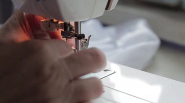 Terzi dikiş makinesini ipliğe geçirir.