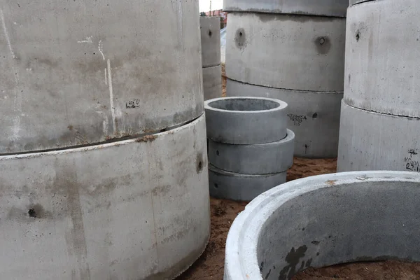 Puddle, dirt and cement rings for piping. Concrete building materials. Construction