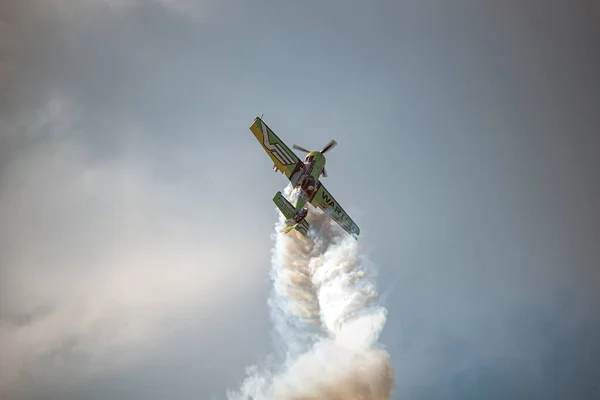 Bükreş, Romanya - 28 Temmuz 2018: Akrobatik uçuş sırasında dublör uçak. Duman izleri ve bulutlar dramatik bir zemin oluşturur