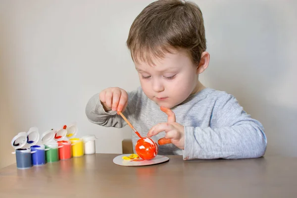 Schattig Mooi Kindje Tekent Paaseieren Met Gekleurde Verf Jongen Zit — Stockfoto