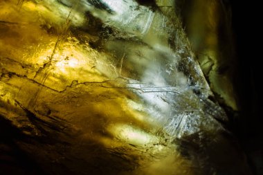 Geçmişi. Aydınlatılmış bir alçı taşı kristalinin içindeki soyut çizimler.