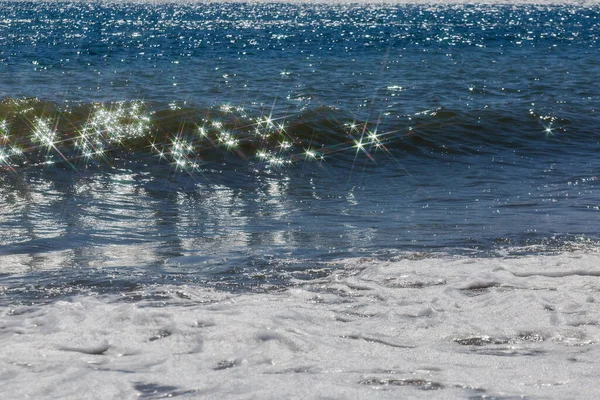 海の波の上に星の形で太陽のまぶしさ サーフィン中の輝く海の波 — ストック写真