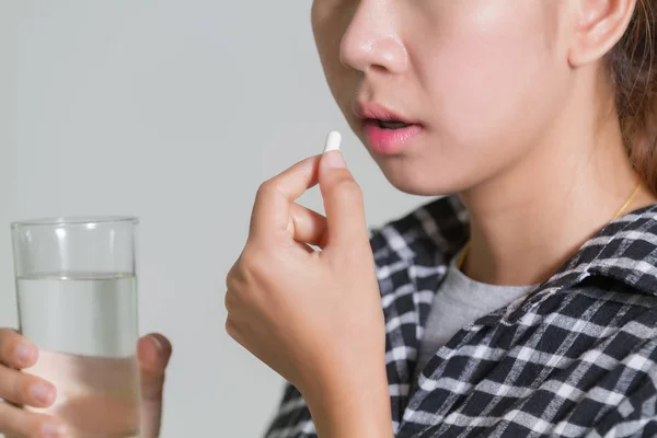 アジア女性を取り、薬を握ると病気や健康のためのビタミンを助ける — ストック写真