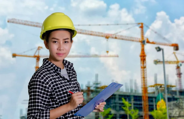 アジア女性エンジニアや技術者の建設現場でボードの一覧をチェックします。 — ストック写真