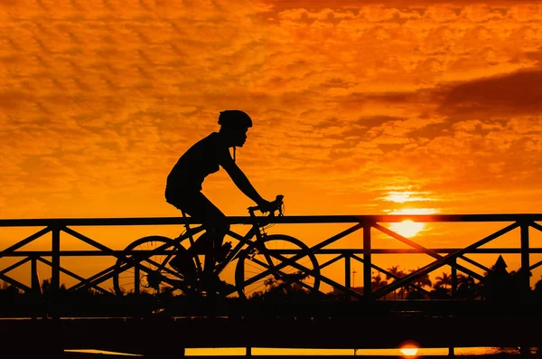 Silhouette eines Radfahrers auf Brücke bei Sonnenuntergang — Stockfoto