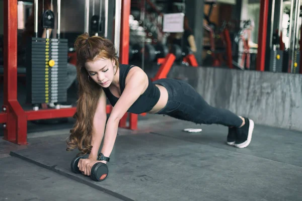 Joven fitness asiático mujer ejercicio y haciendo plancha posición con — Foto de Stock