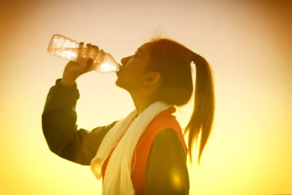 Image floue de femme asiatique sportive boire de l'eau en plein air — Photo