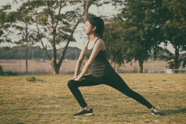 Athletic woman asian warming up and Young female athlete sitting — Stock Photo, Image