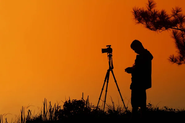 Silhouette A man asia with backpack taking a photo on the top of — Stock Photo, Image