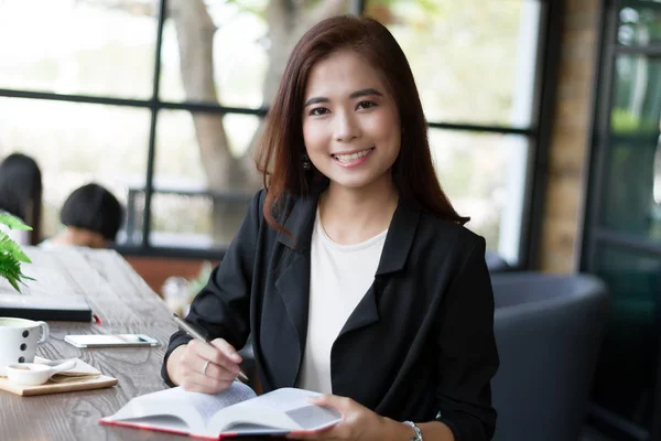 Mujer de negocios asiática sonriendo y leyendo un libro para relajarse —  Fotos de Stock
