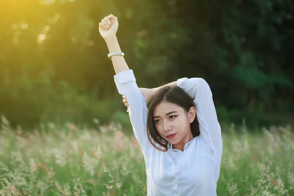 Relajante mujer en el prado de hierba verde en el atardecer de verano y Re —  Fotos de Stock