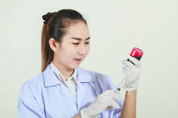 Jeringa de mano con guantes médicos con líquido rojo en la sangre y un —  Fotos de Stock