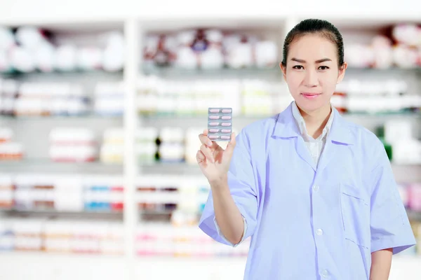 Farmacéutica y doctora mujer sosteniendo píldora en la mano, atención médica a —  Fotos de Stock