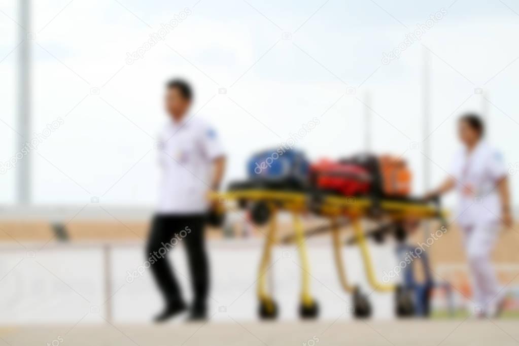 blurry doctor and ambulance car stand by at football stadium for