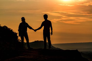 Siluet çiftin holding el gündoğumu gezginler için