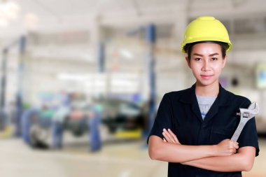 Asyalı kadın mühendis bir İngiliz anahtarı elinde tutan hazırlanan için 