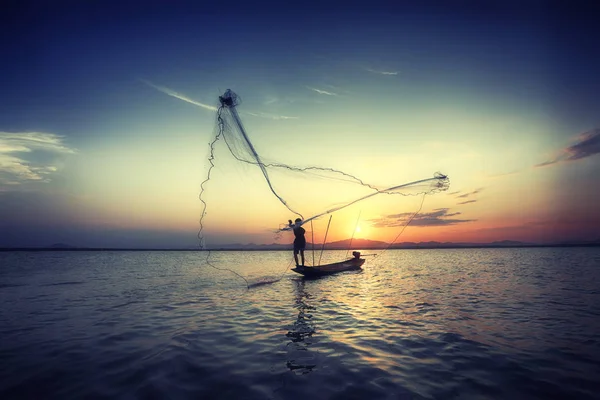 Silueta pescador y barco en el río durante la puesta del sol, Tailandia — Foto de Stock