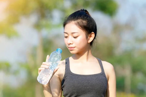 Femme sportive asie boire de l'eau en plein air le jour ensoleillé — Photo