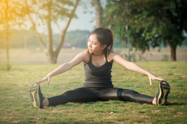 Athletic woman asian warming up and Young female athlete sitting — Stock Photo, Image