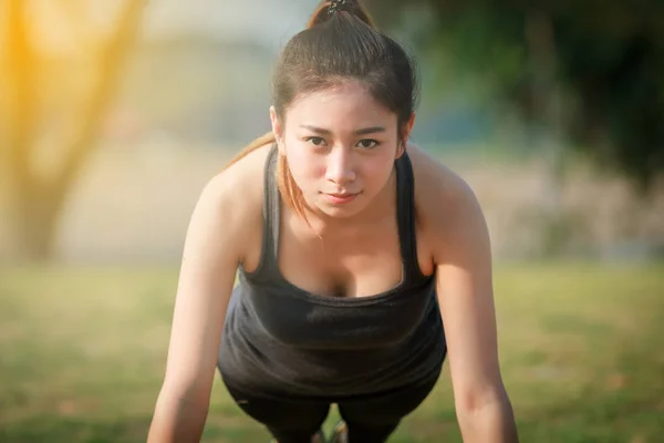 Atlética mujer asiático calentamiento hasta y joven mujer atleta sentado — Foto de Stock