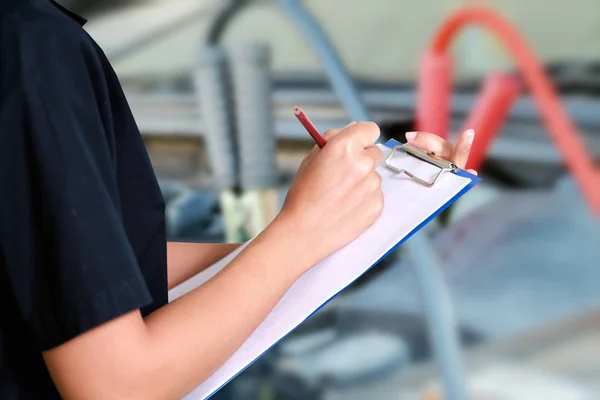 Porträt einer lächelnden jungen Mechanikerin bei der Inspektion eines Autos in — Stockfoto