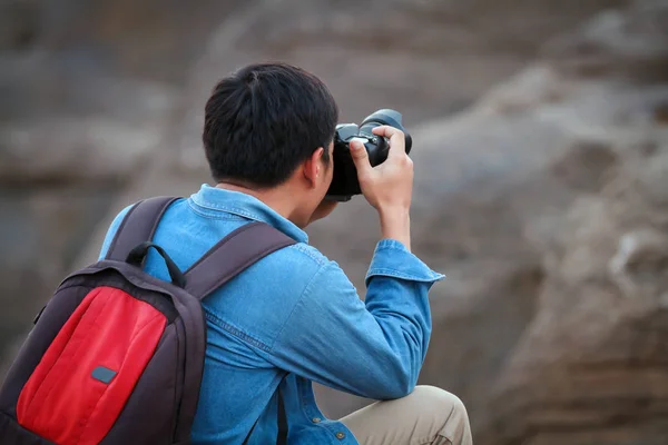 Ein Mann mit Rucksack fotografiert die Gipfel der Berge — Stockfoto