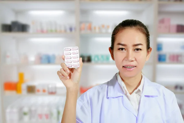 Farmacéutica y doctora mujer sosteniendo píldora en la mano, atención médica a — Foto de Stock