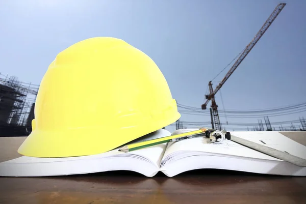 Chapéu duro com bússolas de lápis e réguas / livro na mesa no const — Fotografia de Stock