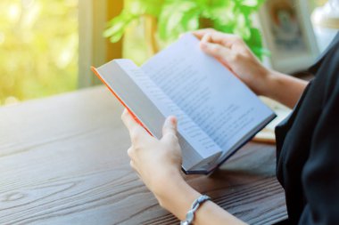 Asyalı kadın dinlenmek için bir kitap okuma .