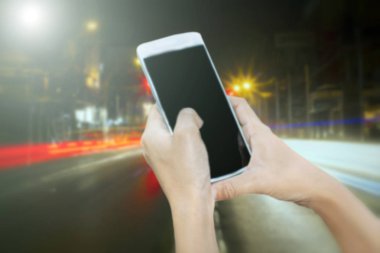 Kadınların Asya tutun ve dokunmatik ekran kullanma akıllı telefon, tablet, sabah background.soft odak şehir trafiğinde telefonda